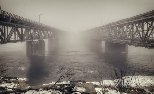 Bridge over river during winter