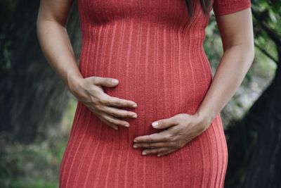 Midsection of pregnant woman standing  outdoors