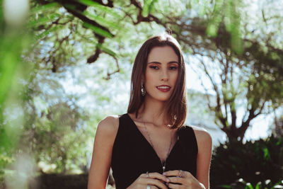 Portrait of beautiful woman against trees