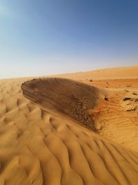 Sand dunes in desert against clear sky