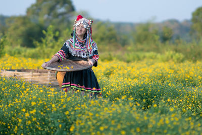 Woman standing on field with yellow flowers