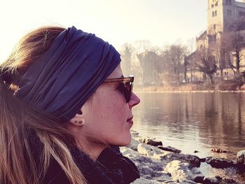 Side view of young woman in sunglasses against sky