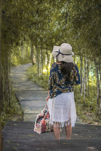 Rear view of woman standing on walkway at park