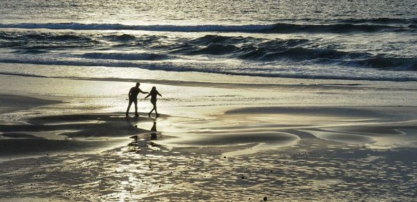 People on beach at sunset
