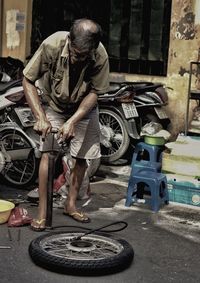 Man working with bicycle in background