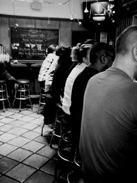 Close-up of people sitting on wall