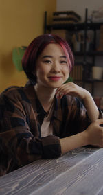 Portrait of young woman sitting on table