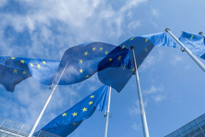 Low angle view of flags against blue sky