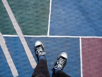 Low section of man standing on tiled floor