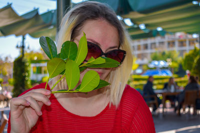 Portrait of woman holding leaf outdoors