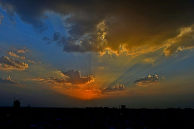 Silhouette city against sky during sunset