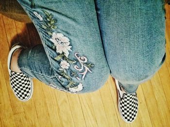 Low section of man wearing shoes on hardwood floor