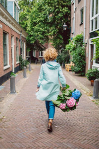 Rear view of woman walking on footpath