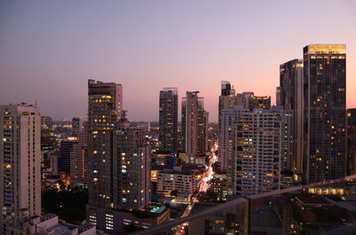 Illuminated buildings against sky at night in city