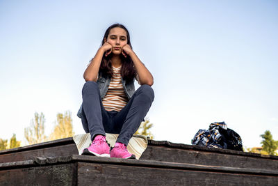 Low angle view of woman standing against clear sky