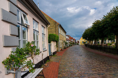 Footpath amidst buildings against sky