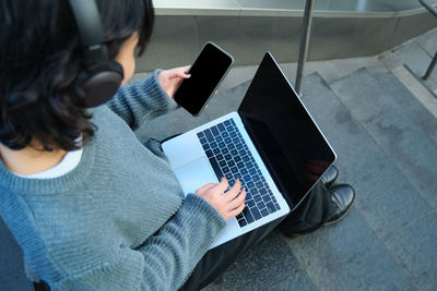 Midsection of woman using laptop at home