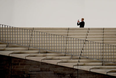 Full length of young woman standing on railing