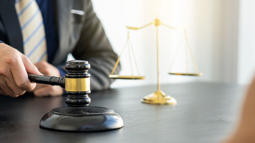 Midsection of man holding wineglass on table