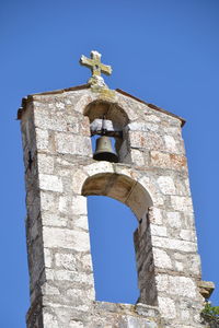 Low angle view of bell tower against blue sky