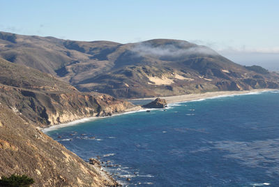 Scenic view of sea and mountains against clear sky