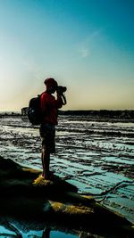 Full length of man standing on beach against clear sky