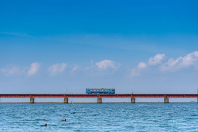 Bridge over sea against blue sky