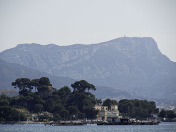 Scenic view of sea by mountains against sky