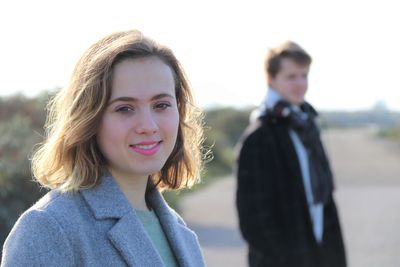 Portrait of a smiling young woman against sky