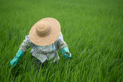 Midsection of person wearing hat on field