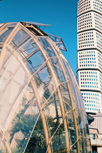 LOW ANGLE VIEW OF ROLLERCOASTER IN CITY