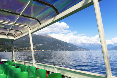 Cropped boat in calm lake against mountain range