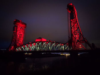 Low angle view of illuminated bridge against sky at night