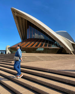 Full length of man on staircase against blue sky