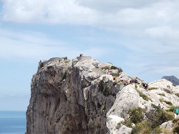 People on cliff against sky