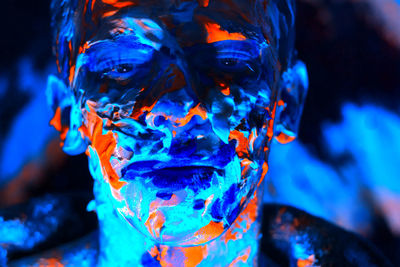 Close-up portrait of man covered with powder paint against black background