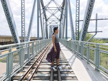 Young woman standing on railway bridge