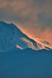 Scenic view of snowcapped mountains against sky during sunset