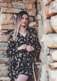 Portrait of woman standing against wall