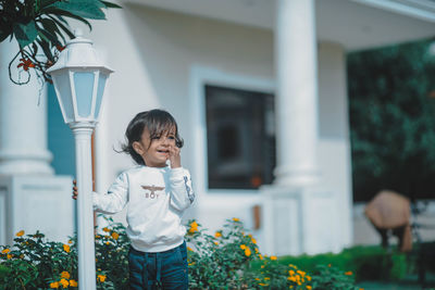 Full length of boy standing by plants