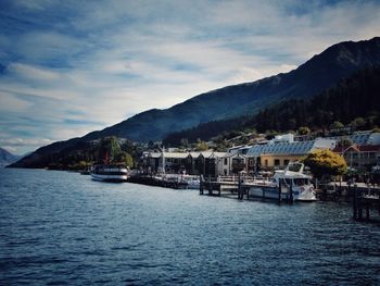 Boats in sea with houses in background