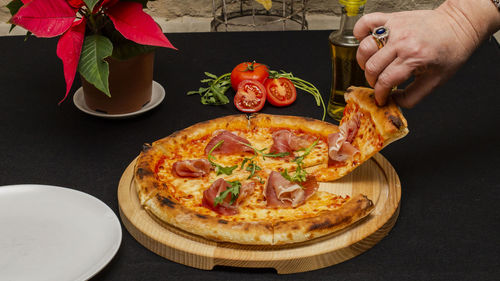 High angle view of hand holding pizza