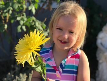 Portrait of a smiling girl with yellow flower