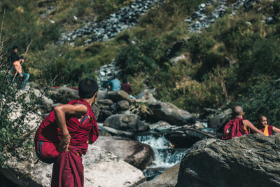 People sitting on rock by rocks