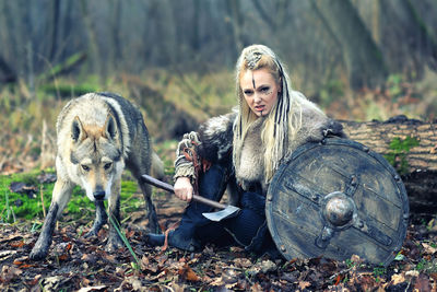 Portrait of woman with wolf in forest