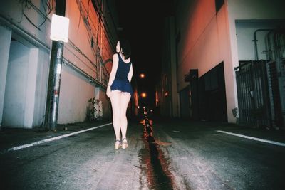 Young woman standing on road at night