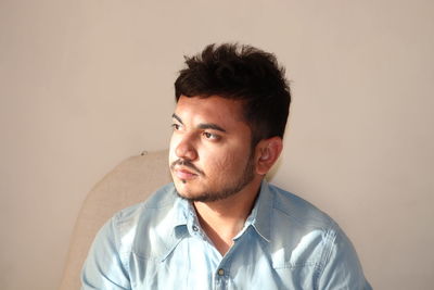 Portrait of a thinking man looking away in denim shirt