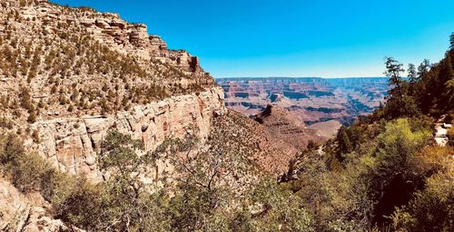 Panoramic view of rocky mountains against blue sky