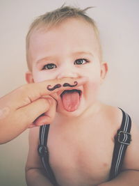 Close-up portrait of baby with fake moustache