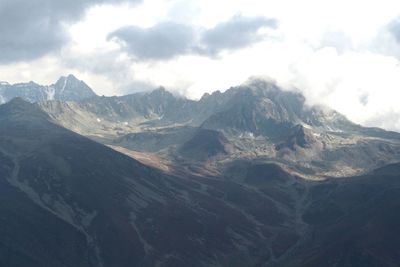 Scenic view of mountains against cloudy sky